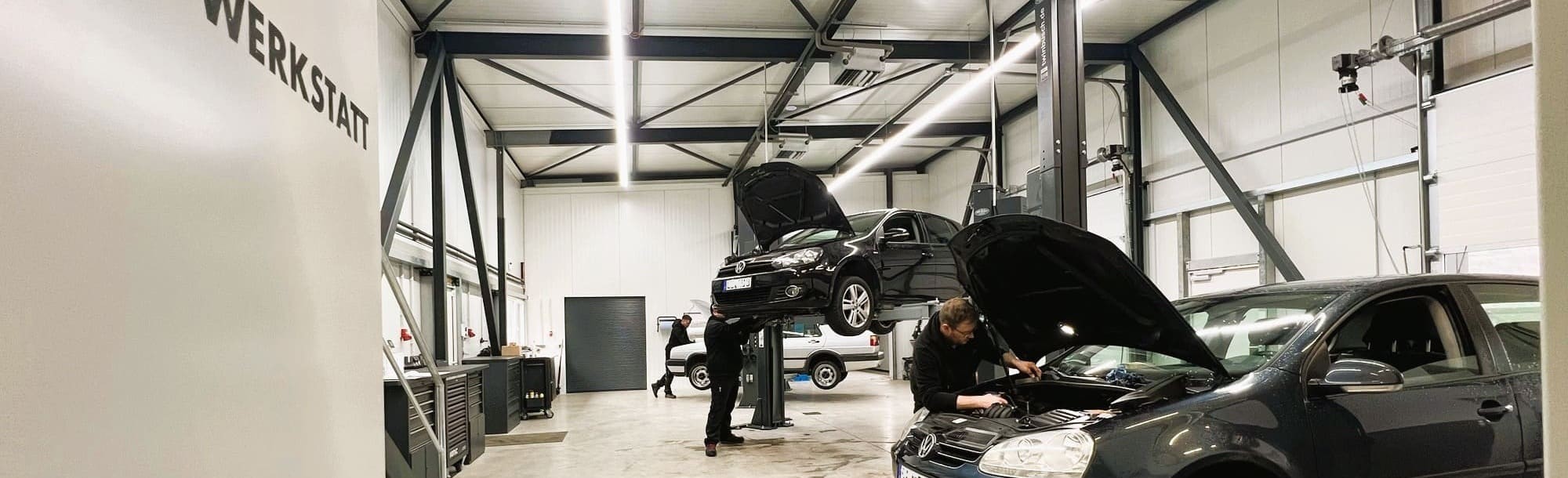 Blick in die Werkstatthalle, in der an Autos gearbeitet wird