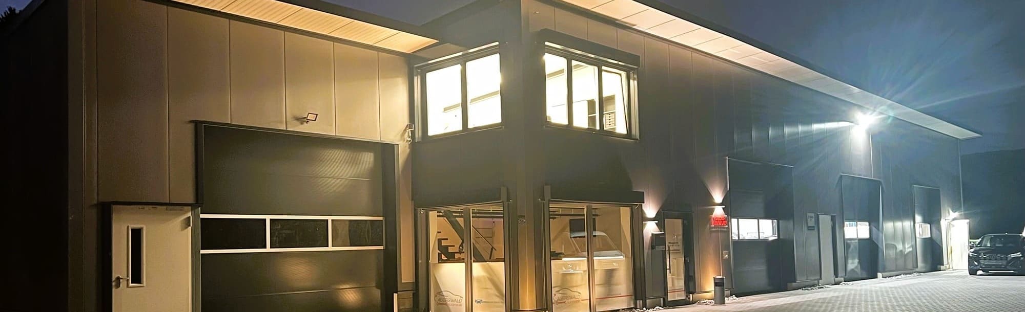 Ansicht des Gebäudes bei Dunkelheit mit erhellten Fenstern