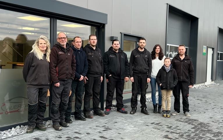 Team der Kfz-Werkstatt vor dem Gebäude