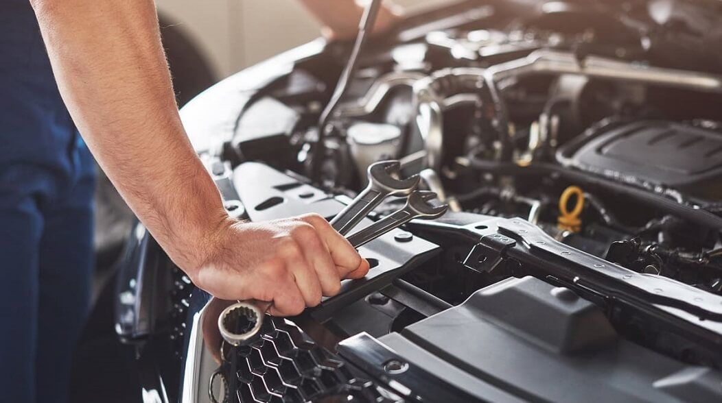 Mechaniker steht vor einer offenen Motorhaube