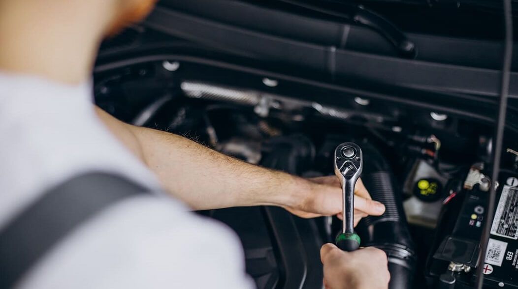 Mechaniker vor einer offenen Motorhaube